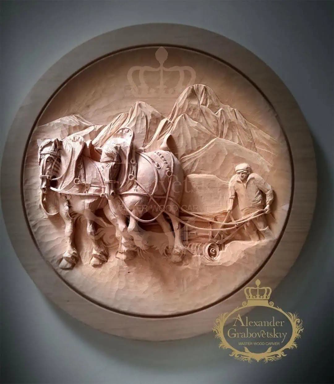 Plowing Team in Mountains Relief Roundel Round limewood relief of a farmer guiding two draft horses plowing before mountains, hand-carved by Alexander Grabovetskiy as custom wood carving.