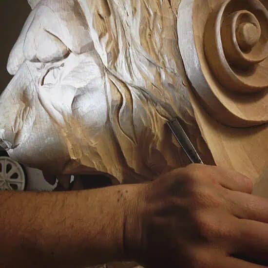Carved Lion Head with Scroll Volute Alexander Grabovetskiy's custom wood carving of a lion's head and scroll in limewood, shown mid-carving.