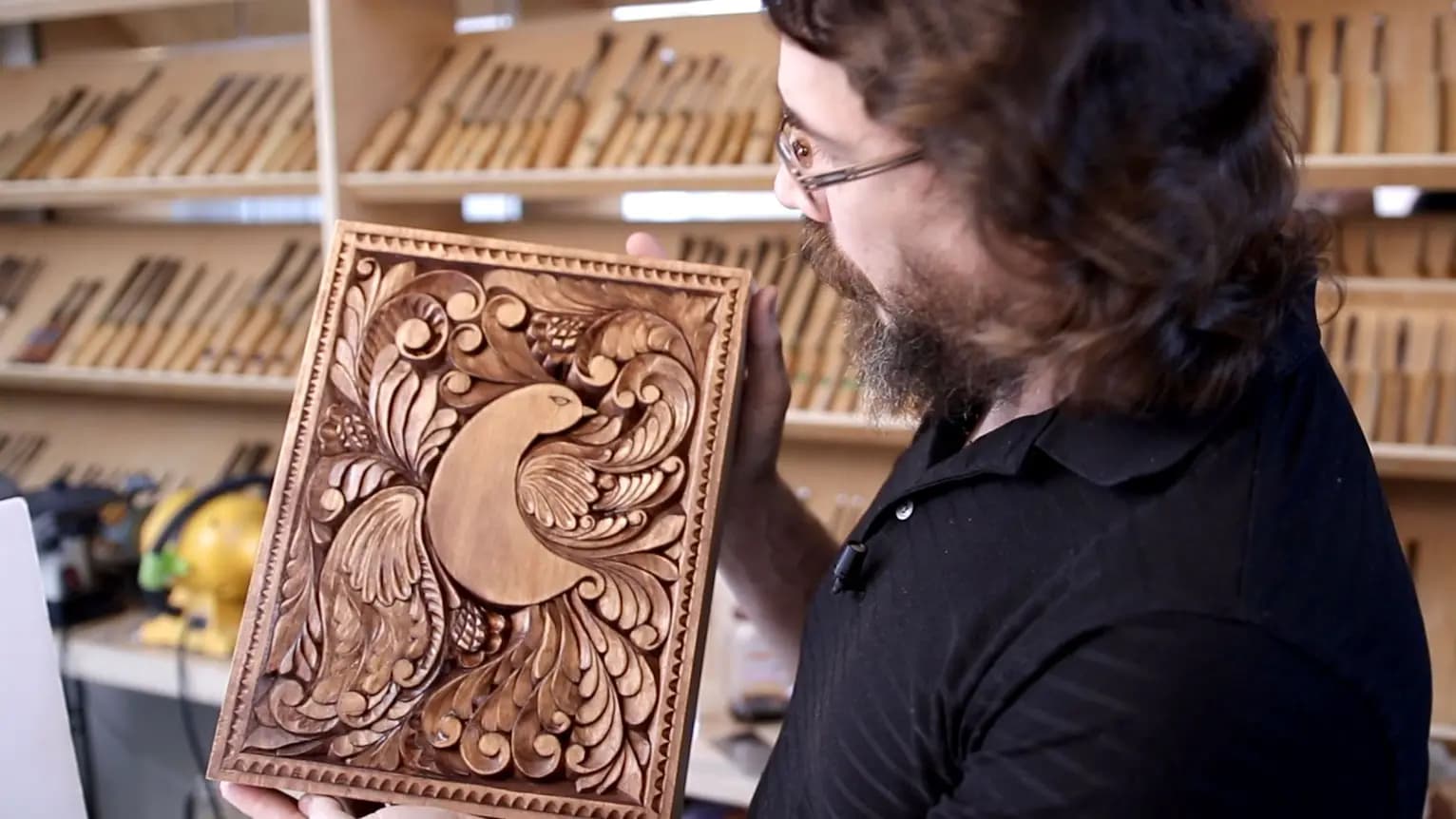 Carved Bird and Acanthus Panel Alexander Grabovetskiy holds a limewood relief panel of a bird amid acanthus scrolls, a custom wood carving.