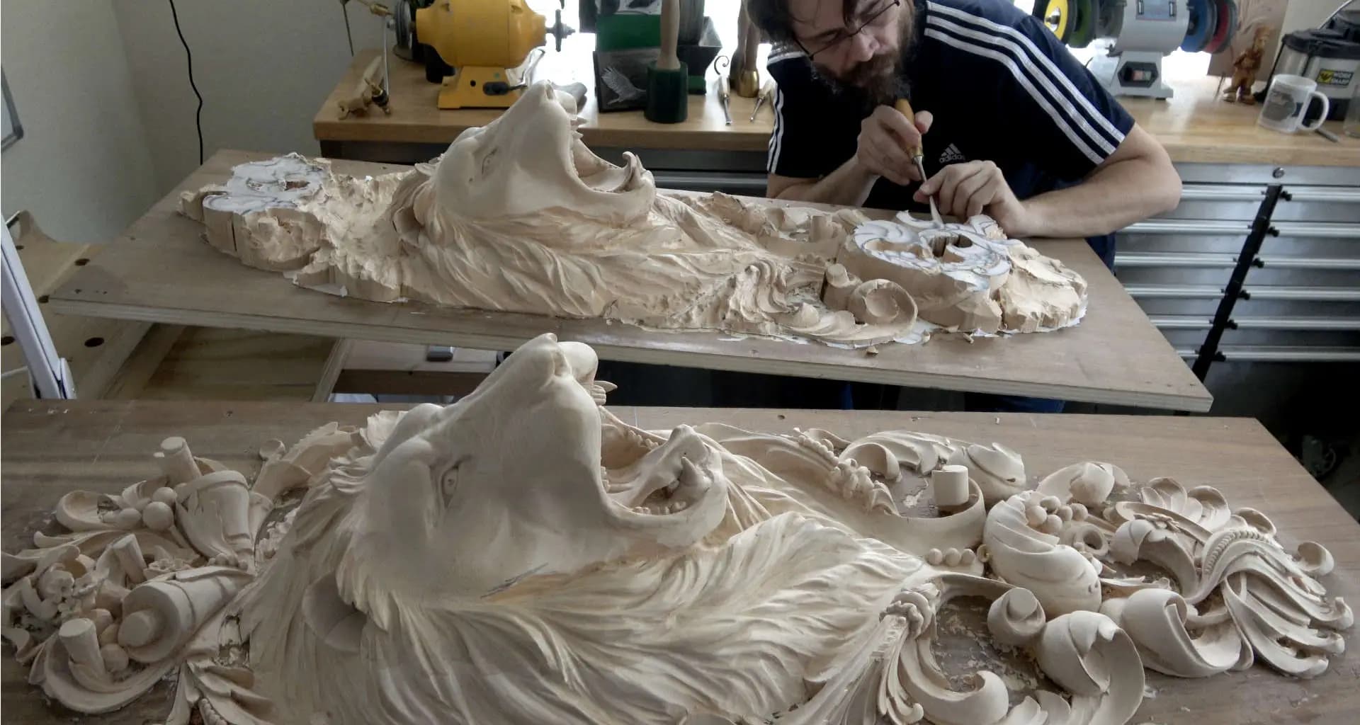 Carved Lion Heads in Limewood Alexander Grabovetskiy carving two roaring lion heads in limewood, a custom wood carving in progress.