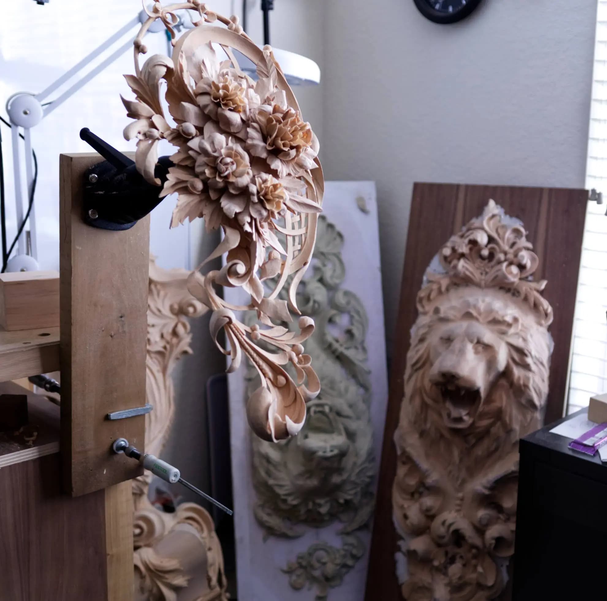 Pierced Floral Cartouche in Limewood Pierced limewood floral cartouche with roses, a custom wood carving by Alexander Grabovetskiy on the bench.