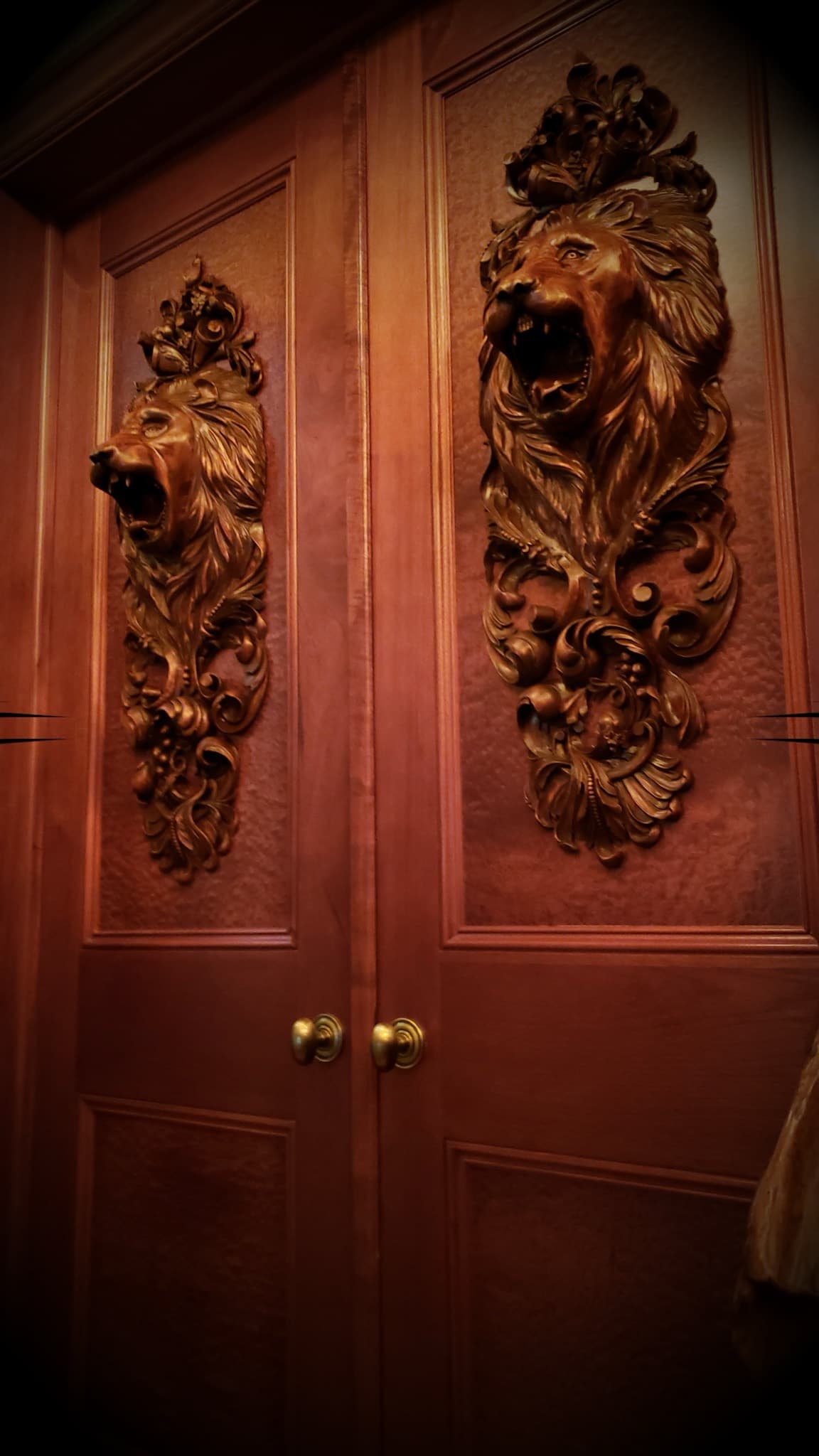 Roaring Lion Door Panels in Relief Two roaring lion head panels with acanthus scrollwork carved by Alexander Grabovetskiy as custom wood carving on double doors.